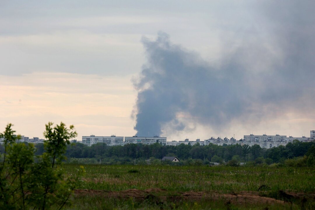 Putin will Pufferzone bei Charkiw - Nach dem Beschuss durch russische Truppen steigt eine Rauchsäule hinter Wohnhäusern in Charkiw auf.