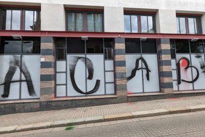 Angriff auf Polizeiwache: Pflastersteine, Barrikaden und Graffiti - Es wurde ein schwarzes Graffiti mit einem Schriftzug in der Größe von 10 x 2,5 Metern angebracht.