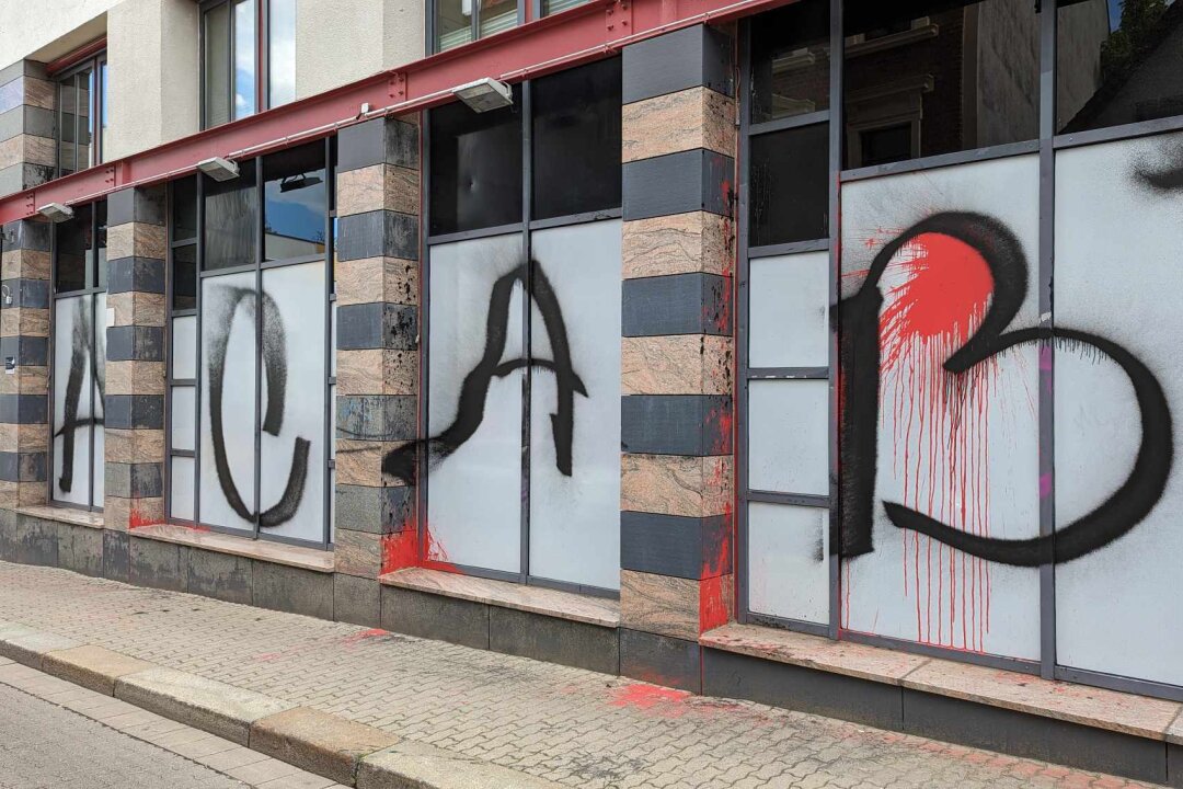 Angriff auf Polizeiwache: Pflastersteine, Barrikaden und Graffiti - Es wurde ein schwarzes Graffiti mit einem Schriftzug in der Größe von 10 x 2,5 Metern angebracht.