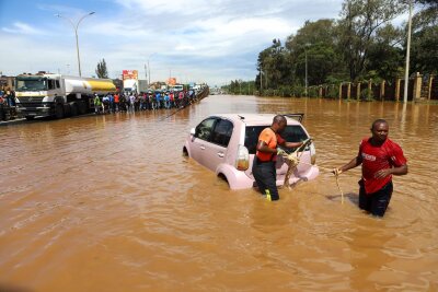 Bereits 257 Flutopfer in Kenia - Menschen in Nairobi, die im Hochwasser ein Auto ziehen.