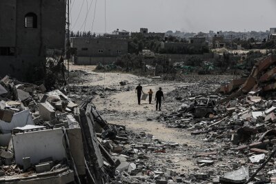 Erneut schwere Kämpfe im Norden Gazas - Palästinenser gehen neben zerstörten Wohngebäuden im Lager Nuseirat im zentralen Gazastreifen entlang.