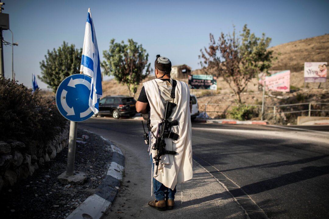 EU verhängt erstmals Sanktionen gegen israelische Siedler - Ein rechtsgerichteter israelischer Siedler trägt eine Waffe nahe der palästinensischen Stadt Nablus im Westjordanland (Archivfoto). Die EU verhängt erstmals Sanktionen wegen der Gewalt radikaler israelischer Siedler.