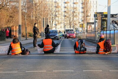 Klima-Aktivisten blockieren erneut Dresdner Stadtverkehr - Klima-Aktivisten kleben sich auf Dresdner Straße fest.Foto: Roland Halkasch