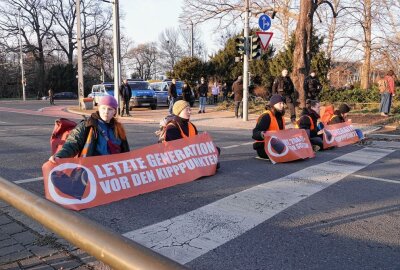 Klima-Aktivisten blockieren erneut Dresdner Stadtverkehr - Klima-Aktivisten kleben sich auf Dresdner Straße fest. Foto: Roland Halkasch