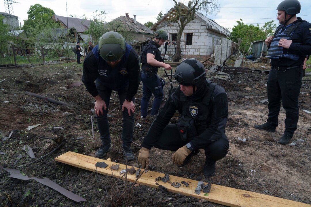 Krieg gegen die Ukraine: So ist die Lage - Ein ukrainischer Polizeibeamter und ein Staatsanwalt für Kriegsverbrechen inspizieren Bruchstücke einer Gleitbombe vor einem beschädigten Haus nach einem russischen Luftangriff auf ein Wohnviertel.