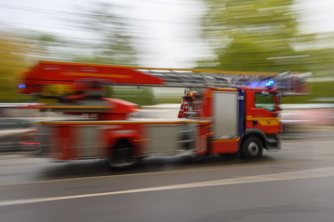 Kurz nach Einsatz: Flammen in Dresdner Industriebrache - Ein Feuerwehrfahrzeug mit Drehleiter fährt in der Innenstadt zu einem Einsatz.