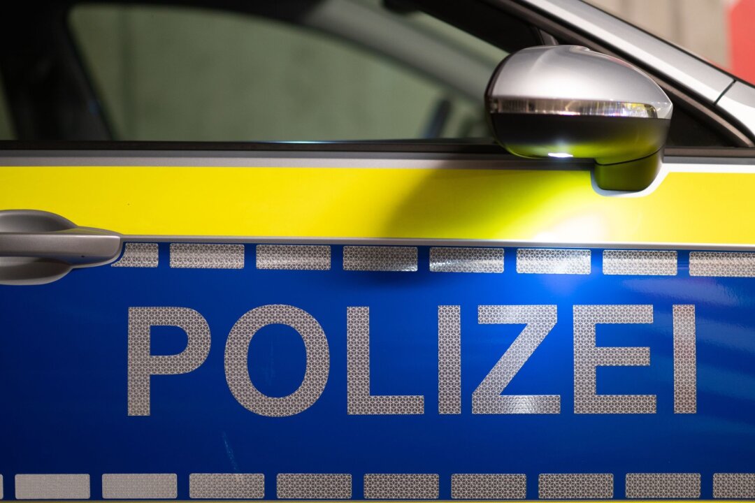 Leichenfund in Leipzig: Opfer ist 43-jähriger Mann - „Polizei“ ist auf der Tür eines Polizeiautos zu lesen.