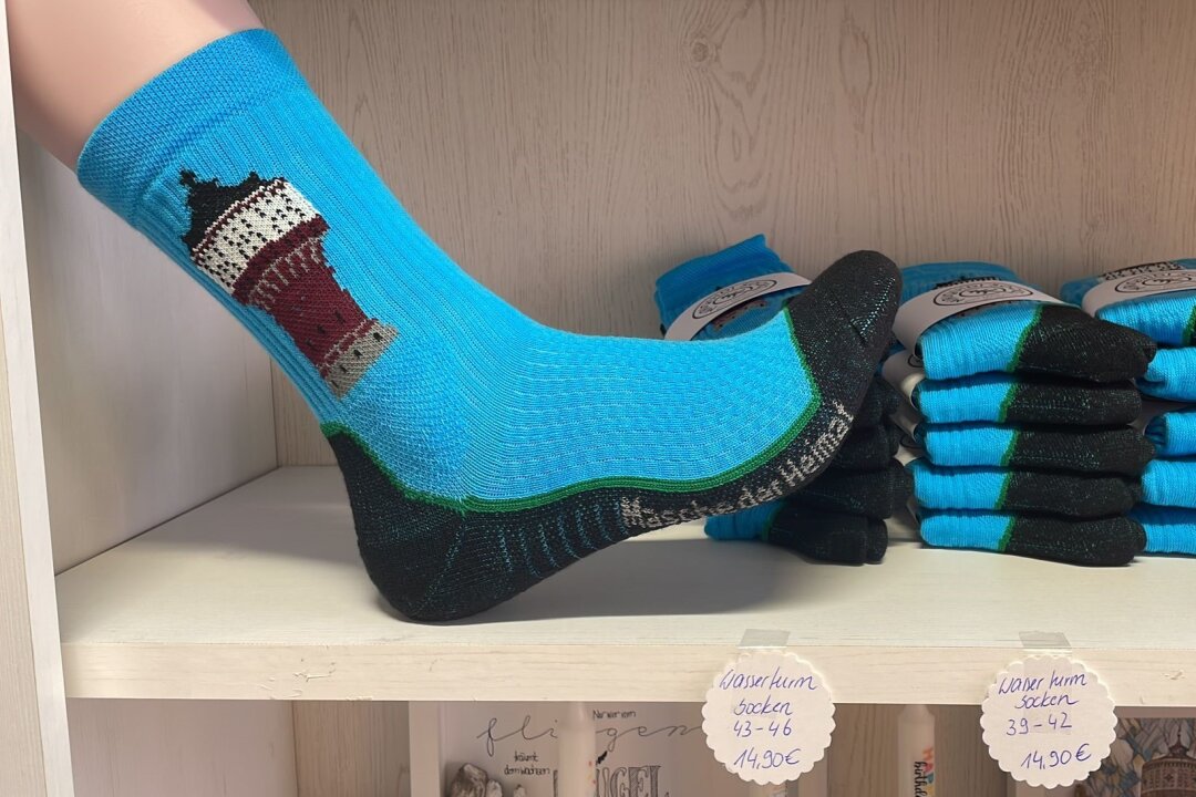 Ein Fuß, welcher die Socke trägt und weitere im Ladenregal mit den Preisen.