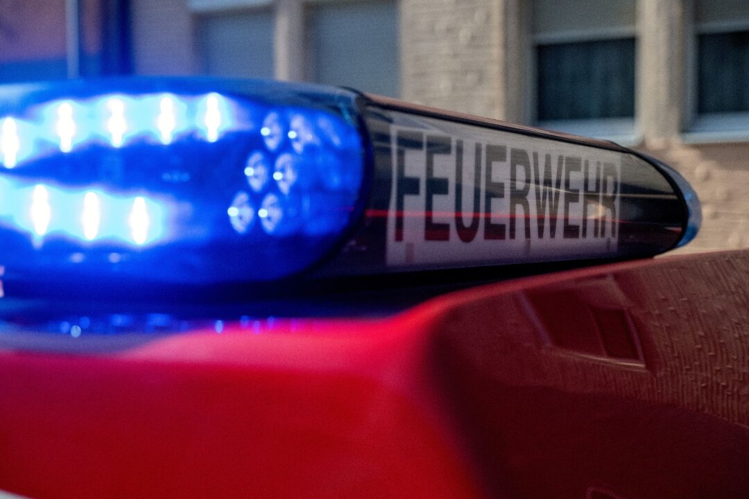 Menschen durch Chlorgas an Oberschule in Delitzsch verletzt - Ein Fahrzeug der Feuerwehr steht mit eingeschaltetem Blaulicht an einem Einsatzort.