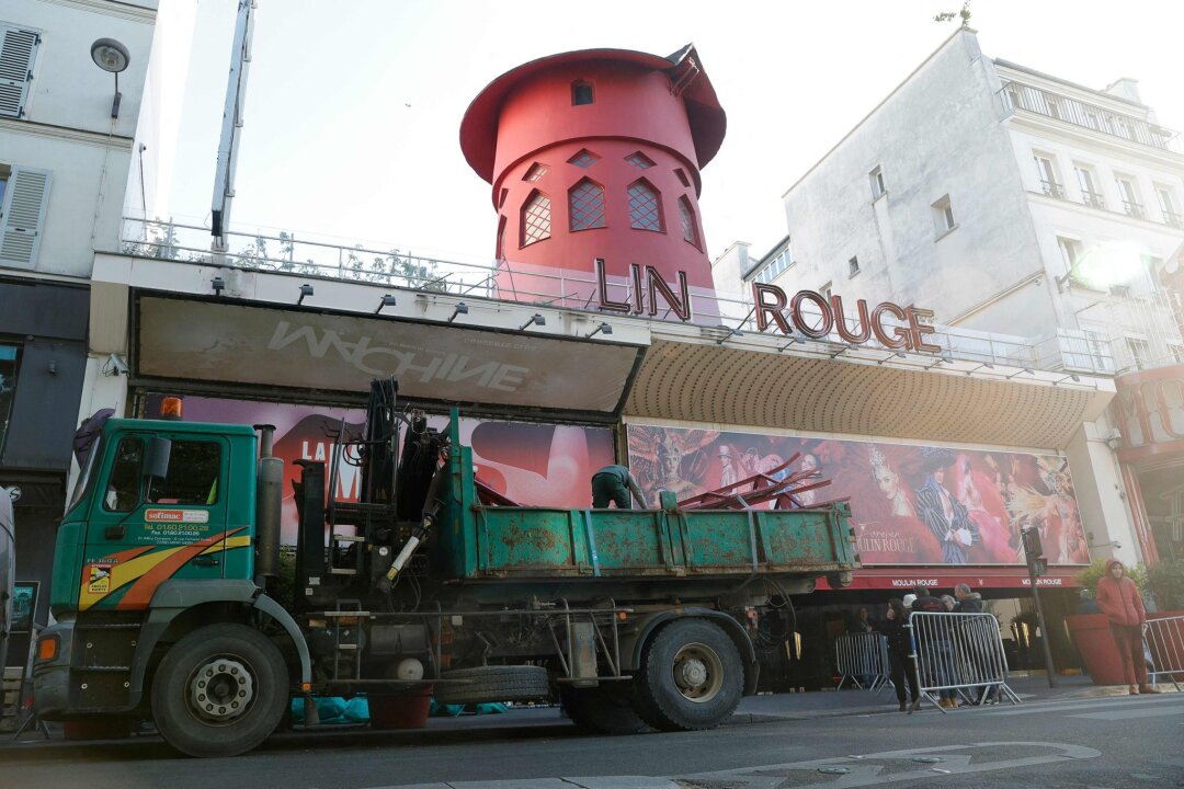 Mühlrad des Pariser Cabarets Moulin Rouge stürzt ab - Arbeiter sichern den Bereich vor dem Kabarett, nachdem die Flügel des Windrads des "Moulin Rouge" in der Nacht abgestürzt sind.