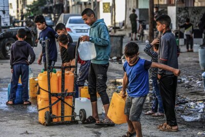 "Obdachlose ohne Zukunft" in Gaza - Kinder stehen in Rafah mit Kanistern Schlange, um sie mit Trinkwasser zu füllen.