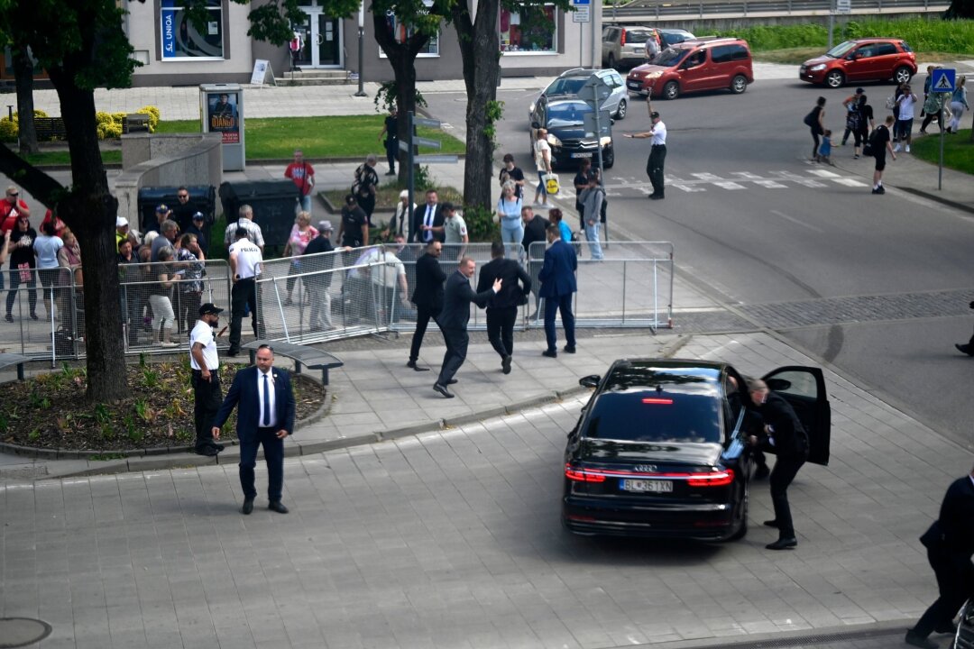 Slowakischer Regierungschef nach Schüssen in Lebensgefahr - Leibwächter bringen den slowakischen Ministerpräsidenten Robert Fico in einem Auto vom Ort des Geschehens in Sicherheit.