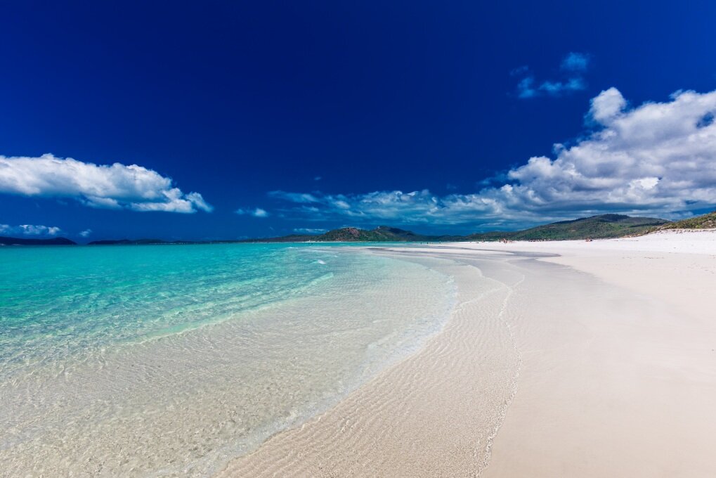 Der Whitehaven Beach in Australien gilt als der schönste Strand dort. Im Osten des Landes. Der Strand mit dem weißen Sand, der bei strahlendem Sonnenschein in den Augen blendet, dem türkisblaue Wasser und der atemberaubenden Kulisse befindet sich auf den Whitsunday Islands im gleichnamigen Nationalpark. Aufgrund des Quarzanteils von fast 99 Prozent gehört der Whitehaven Beach zu den weißesten Stränden der Welt.