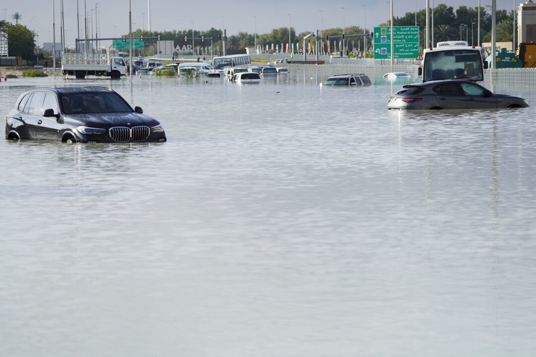 Überschwemmungen in Dubai: Schwerster Regen seit 1949 - Fahrzeuge stehen verlassen im Hochwasser auf einer Hauptstraße in Dubai.