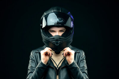 Eine Frau hat einen schwarzen Motorradhelm auf.