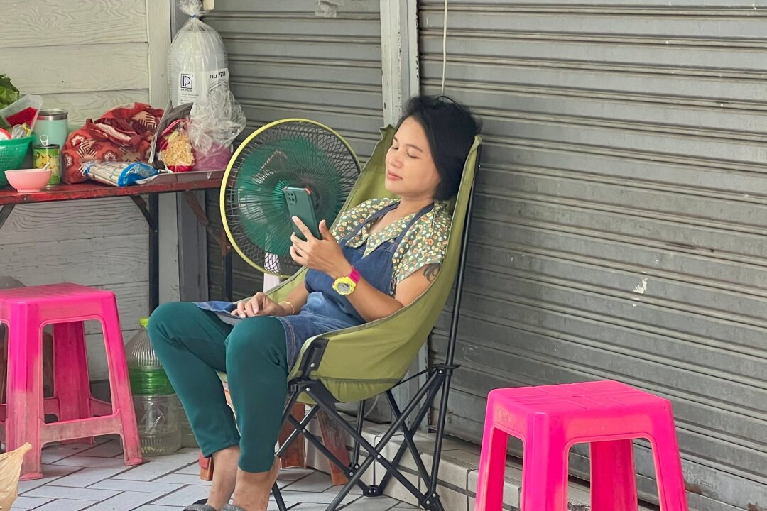 Wie im Backofen: Rekord-Hitzewelle von Thailand bis Vietnam - Im Schatten und mit Ventilator: Eine Frau in Bangkok versucht, sich sich abzukühlen.