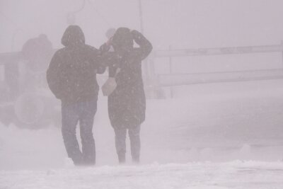 Wintereinbruch im Erzgebirge: Dichter Schneefall sorgt für glatte Straßen - Touristen im Schneesturm: Fichtelberg von eisigem Wind überrascht