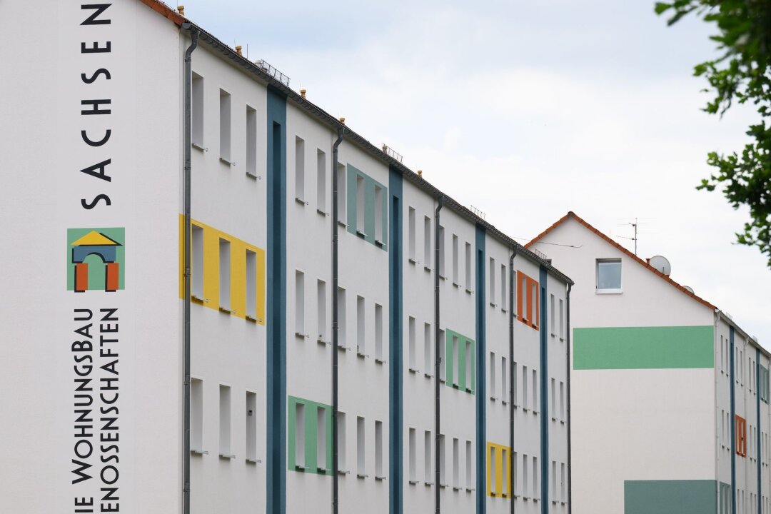 Wohnungsgenossenschaften: Trotz Investitionen weniger Neubau - Das Logo der Wohnungsgenossenschaft Dippoldiswalde steht an der Fassade eines Wohnblocks.