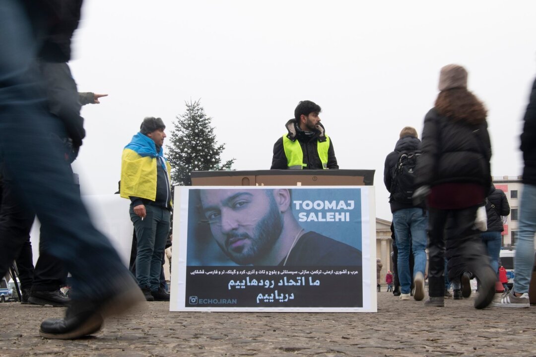 Zeitung: Iranischer Rapper Salehi zum Tode verurteilt - Protestaktion gegen Irans Staatsführung auf dem Pariser Platz in Berlin. Auf dem Plakat ist der Rapper Salehi zu sehen.