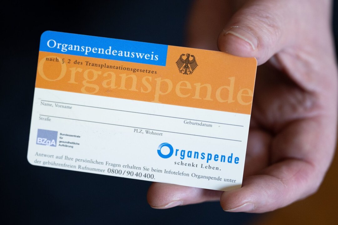 2023 mehr Organspender und Organtransplantationen in Sachsen - Eine Frau hält einen Organspendeausweis in der Hand.