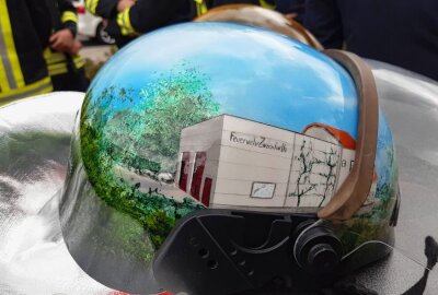 24 Blaulicht-Fahrzeuge überraschten Wehrleiter der FF Zweenfurth - Auf einem der an Tilo Melzer übergebenen Helme prangt das Zweenfurther Feuerwehrhaus. Foto: Anke Brod