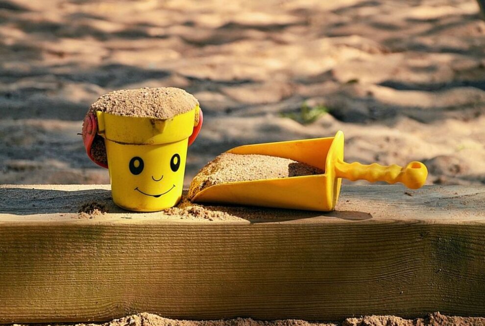 Symbolbild. Sandspielzeug liegt neben einem Sandkasten. Foto: Pixabay