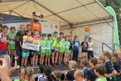 Dritt- und Viertklässler aus der Grundschule in Crossen freuen sich bei der Triathlon-Siegerehrung über den Gutschein. Foto: Holger Frenzel