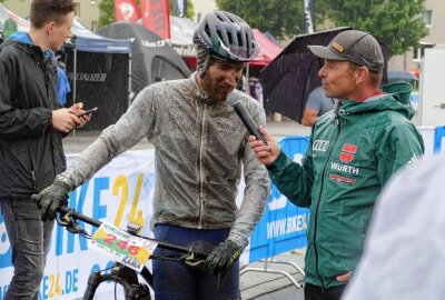 700 Mountainbiker lassen sich in Seiffen vom Regen nicht stoppen - Im Ziel interviewte Organisationsleiter Albrecht Dietze viele Teilnehmer. Foto: Andreas Bauer