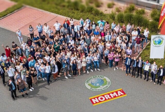 Daumen hoch für eine nachhaltige Zukunft: NORMA-Mitarbeitende und die Geschäftsleitung versammelten sich zur Übergabe des Zertifikats von Green Band vor dem Unternehmenssitz in Fürth. Foto: Norma