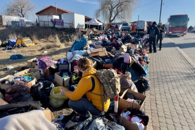 Als Reporter vor Ort an der ukrainischen Grenze - Helfer sitzen zwischen Kleidung. 