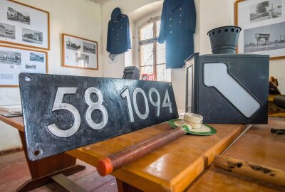 Alter Eisenbahnwaggon dient in Lugau als neues Museum - Ein altes Dampflokschild, eine Weichenlaterne und eine Schaffnerkelle vom Lugauer Bahnhof. Foto: ERZ-Foto/Georg Ulrich Dostmann
