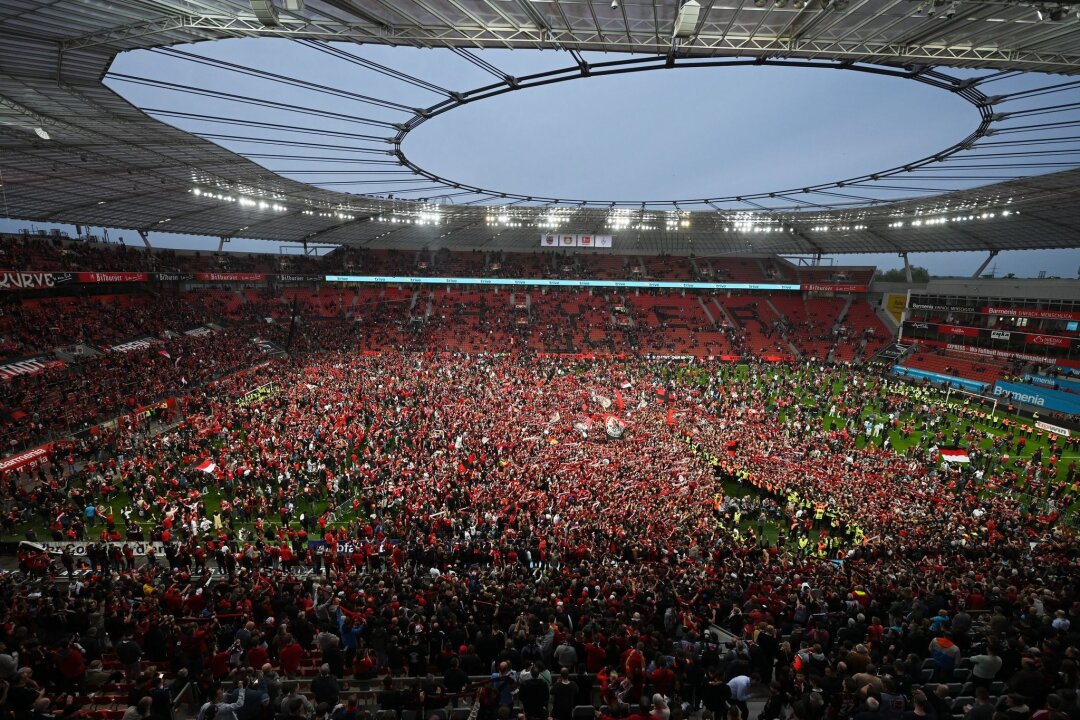 Am Tag nach dem Pokalfinale: Meisterfeier im Stadion - Leverkusens Fans bejubeln auf dem Rasen den Gewinn der Deutschen Meisterschaft.