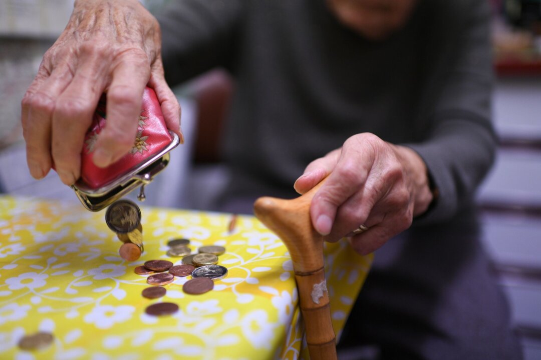Anstieg bei Empfängern von Grundsicherung - Jede Münze zählt: Eine Rentnerin mit ihrem Inhalt ihres Geldbeutel.