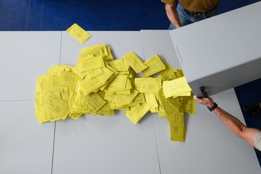 Appell von Stiftungen: Verteidigung Demokratie bei Wahlen - Stimmzettelumschläge für eine Briefwahl werden aus einer Wahlurne geschüttet.