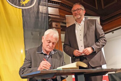 Auerbacher Bürgerpreis verliehen - Ulrich Mikulcak trägt sich ins Goldene Buch der Stadt Auerbach ein. Foto: Thomas Voigt