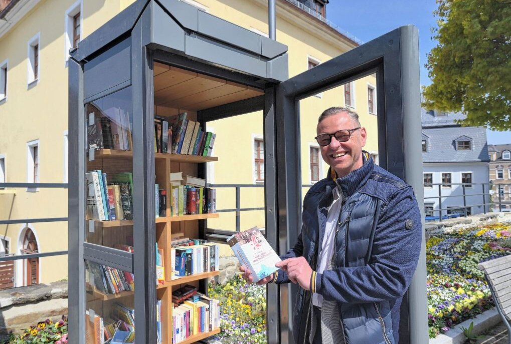 Bürgermeister Ingo Seifert vor der Büchertauschzelle, die auf dem Frauenmarkt in Schneeberg aufgestellt worden ist. Foto: Ralf Wendland