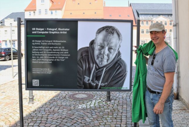 Rolf Büttner vom Organisationsteam der Perspektiva half beim Aufbau der Bilder in der Oederaner Innenstadt mit. Foto: Knut Berger
