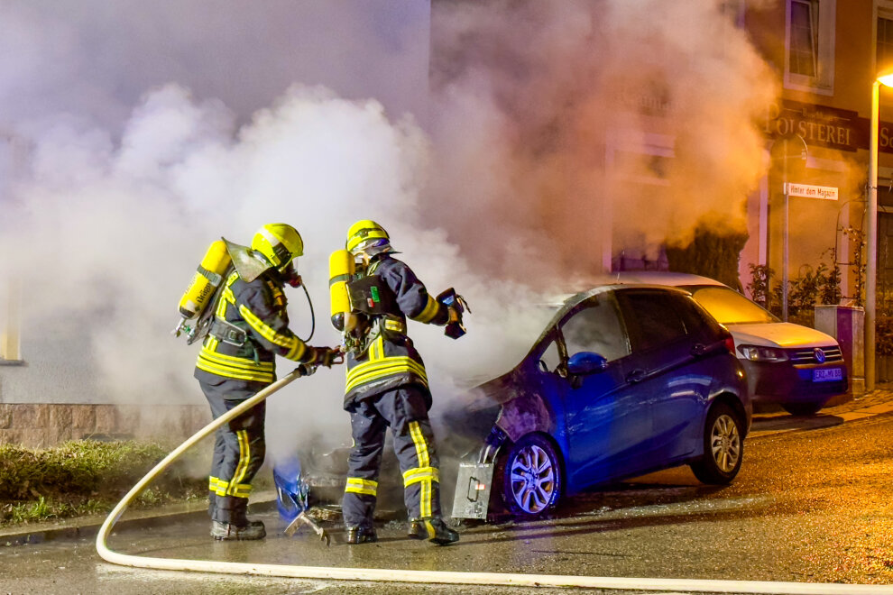 Auto in Flammen: Polizei ermittelt wegen Brandstiftung - Feuerwehr löscht brennenden PKW an der B93.