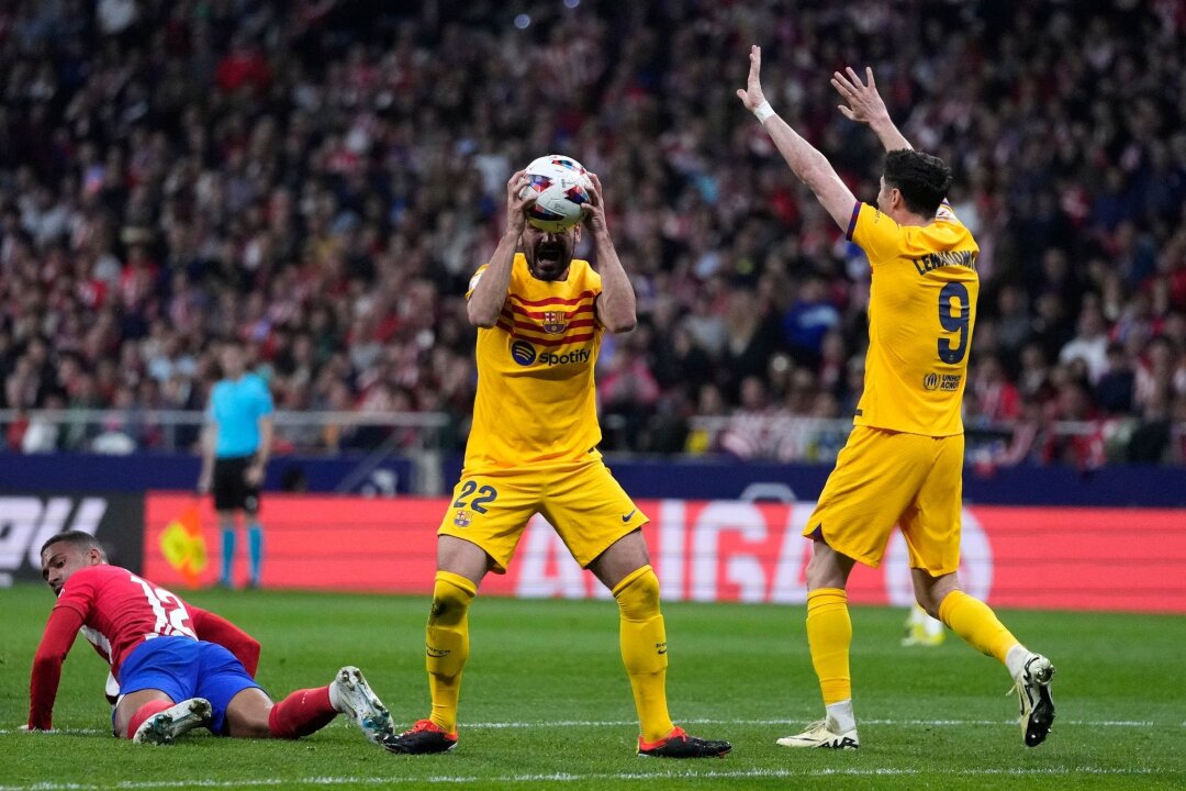 Barcelona siegt deutlich bei Atlético - Lewandowski überragt - Barcelonas lkay Gündoğan (M) und Robert Lewandowski (r) ärgern sich über eine Schiedsrichterentscheidung.
