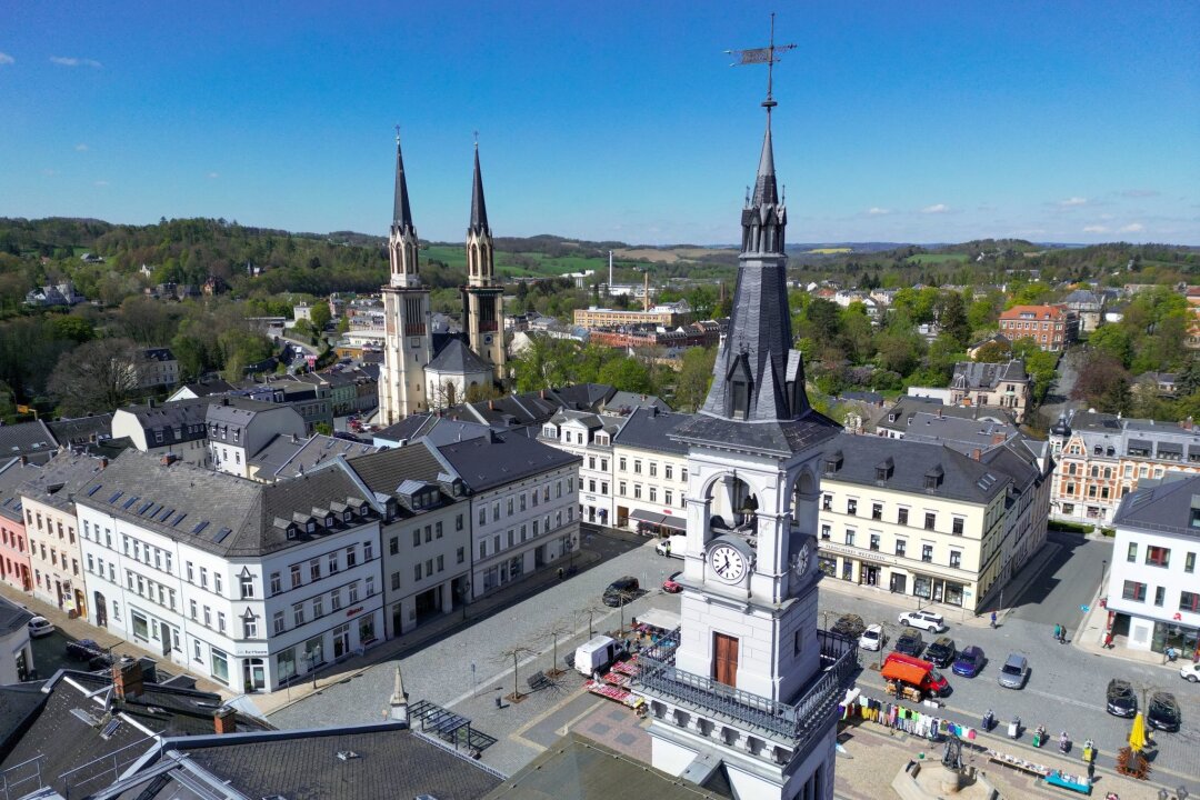 Baukosten machen Kirchgemeinden zu schaffen - Die Doppeltürme der Stadtkirche St. Jakobi ragen hinter dem Marktplatz von Oelsnitz empor.