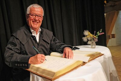 Bergknappe Gert Müller ist Plauens neuer Ehrenbürger -  Gert Müller trägt sich ins Goldene Buch der Stadt ein. Foto: Thomas Voigt 
