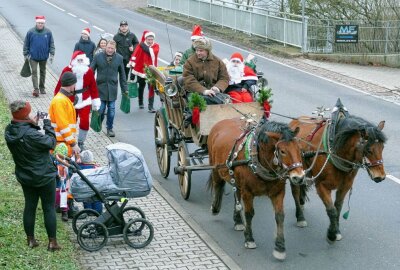 Besondere Tour macht Kinder in Grünhainichen glücklich - Viele hielten den Besuch des Weihnachtsmanns mit dem Handy fest. Foto: Andreas Bauer
