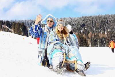 Buntes Treiben beim 104. Skifasching in Oberwiesenthal - Das Prinzenpaar Rebecca und Niclas mit dem Schlitten am Skihang unterwegs. Foto: Thomas Fritzsch/PhotoERZ