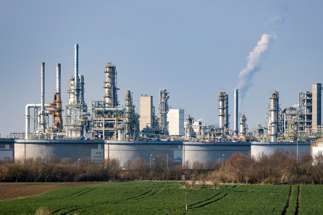 Chemieverband will Sicherheit für Standorte und Beschäftige - Hinter einem Tanklager ragen die Anlagen der Total-Raffinerie in die Höhe.