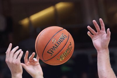 Chemnitz festigt mit Sieg gegen Bonn zweiten Tabellenplatz - Spieler greifen nach einem Basketball.