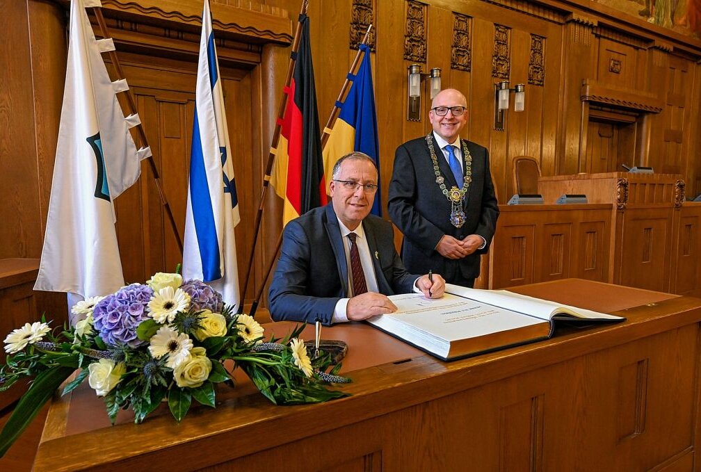 Chemnitz schließt neue Städtepartnerschaft - Eli Dukorski und Sven Schulze tragen sich ins goldene Buch der Stadt Chemnitz ein. Foto: Andreas Seidel