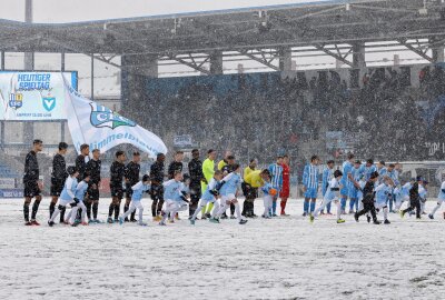 Chemnitzer Kicker rutschen auf Schnee nicht aus - Die Mannschaften betreten den Rasen. Foto: Harry Härtel