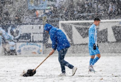 Chemnitzer Kicker rutschen auf Schnee nicht aus - Technische Mitarbeiter des CFC schippen Schnee, um das Spielfeld bespielbar zu machen. Foto: Harry Härtel