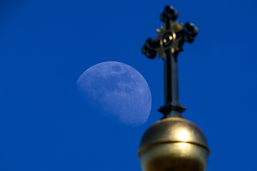 Christliche Kirchen mit Aufruf zu gewissenhafter Wahl - Der Mond ist am Himmel hinter dem Kreuz der Dreikönigskirche zu sehen.