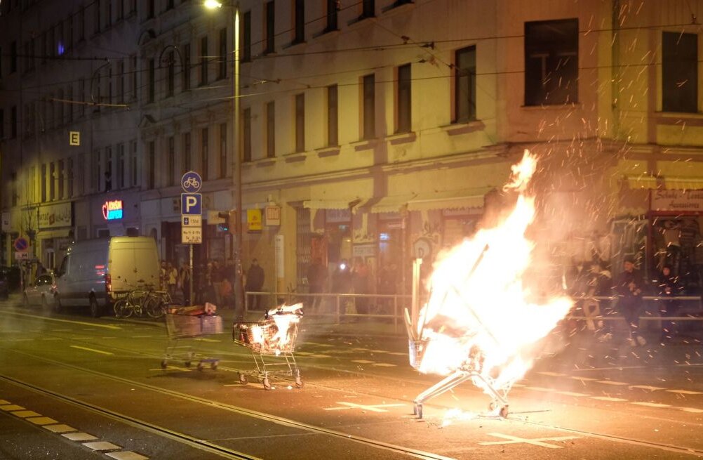 Ausschreitungen in Leipzig: Einkaufswagen mit brennenden Gegenständen stehen auf der Eisenbahnstraße.